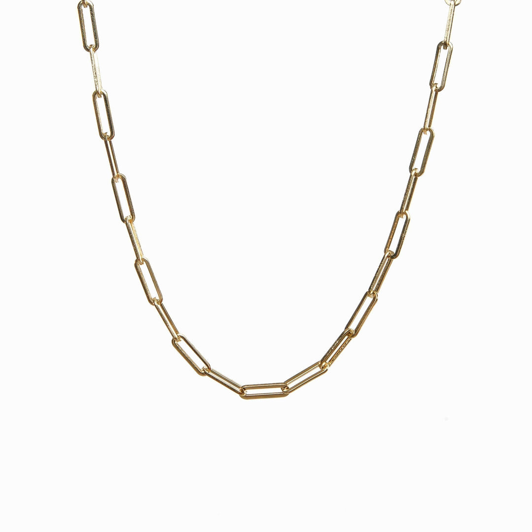 Radiant gold choker necklace laid flat on a white surface