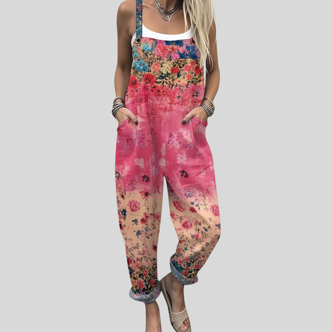 Women's wide-leg dungarees with a vivid fuchsia-to-peach ombré ground and scattered multicolour floral print, from Mary Cork Ireland.