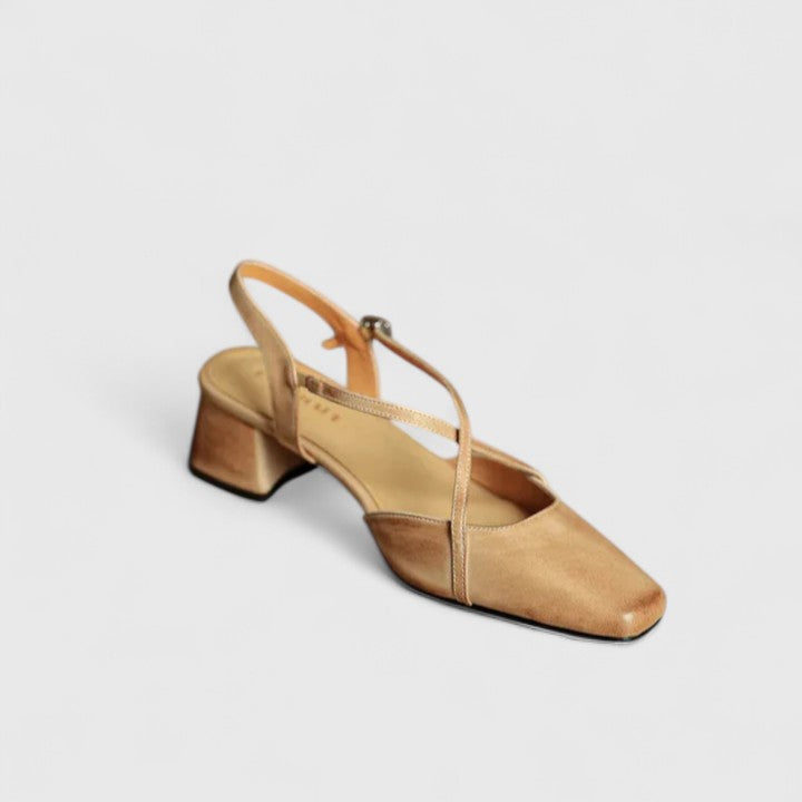 A woman wearing beige chic block heel sandals with an adjustable strap at an evening event.