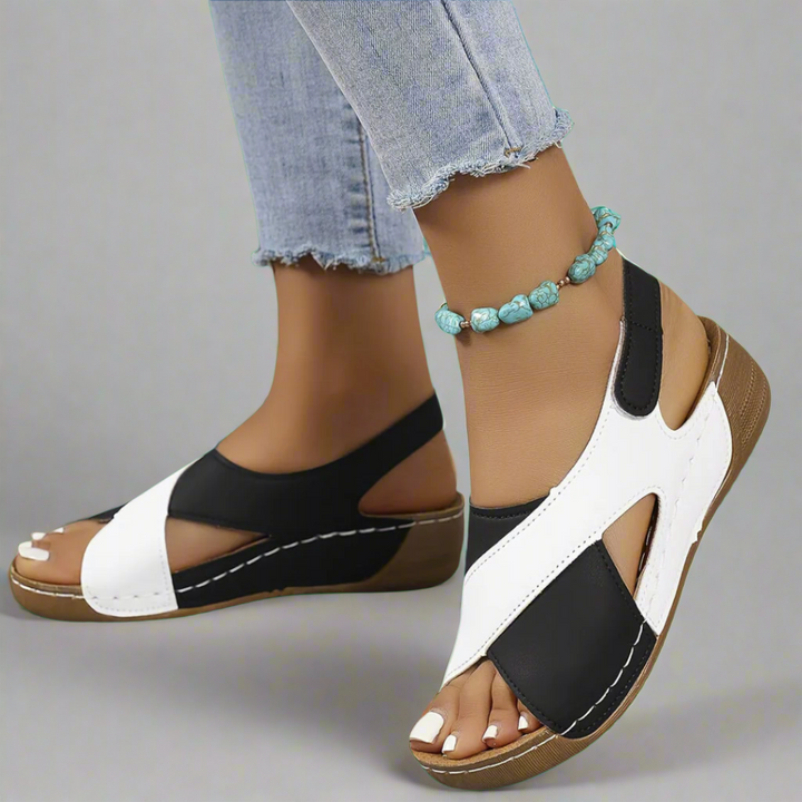 A woman walking outdoors in modern colourblock orthopaedic sandals with adjustable straps.