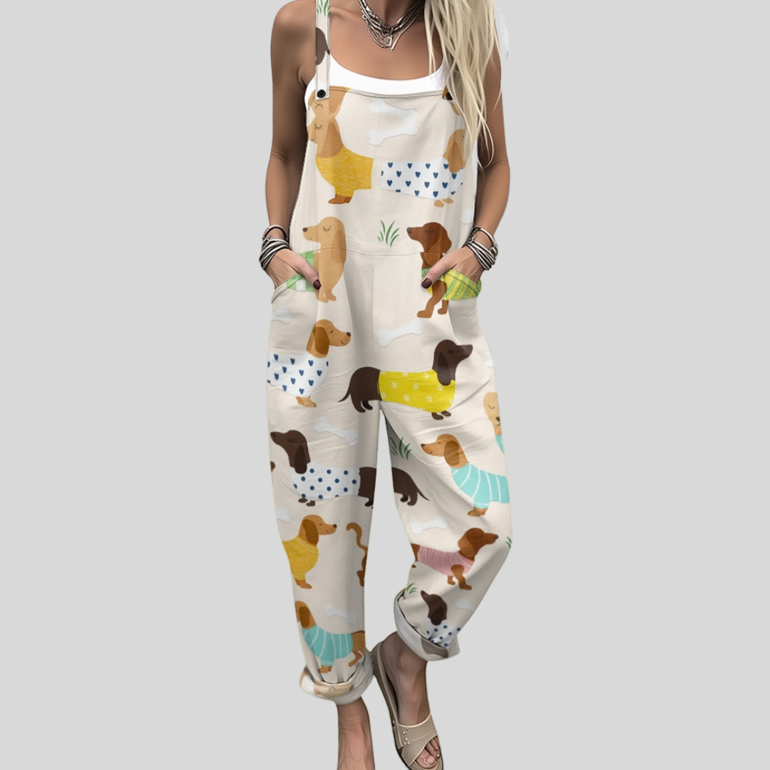 Women's relaxed wide-leg dungarees in cream with a whimsical print of small dachshunds wearing colourful jumpers.