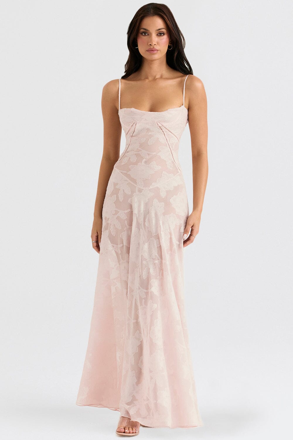 An elegant floor-length occasion dress in blush pink, styled for a formal wedding or gala event