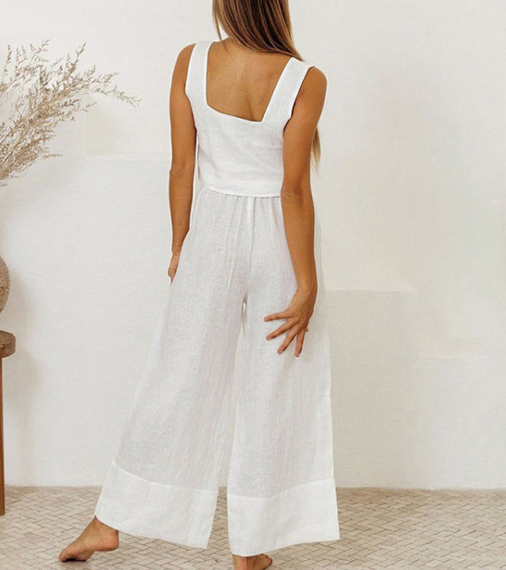 A woman wearing a minimal two-piece set with a square neckline and belted flared trousers.