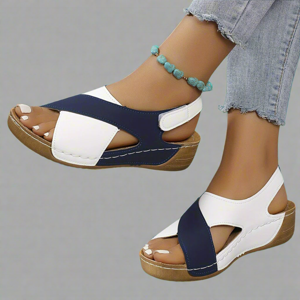 A woman walking outdoors in modern colourblock orthopaedic sandals with adjustable straps.