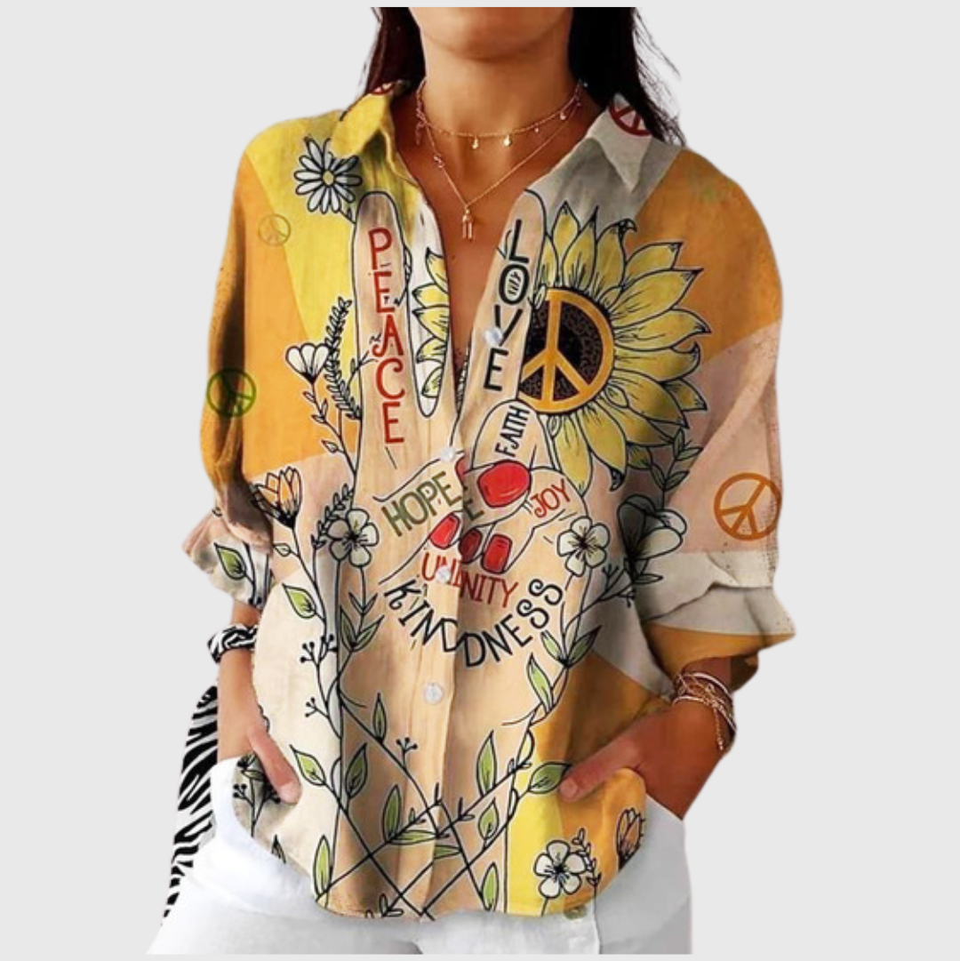 A woman wearing a vibrant floral printed blouse, relaxed and smiling