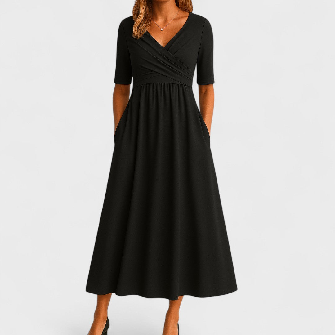 Woman wearing a mid-calf dress with a crossover V-neckline, gathered waist and gently flared skirt.