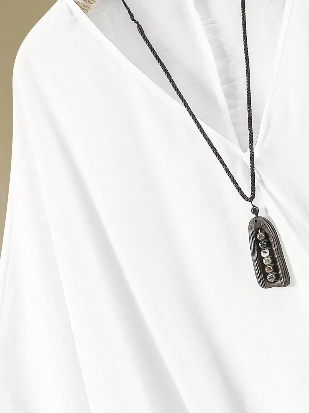 A woman wearing a flowing V-neck knot-detail top with matching flared trousers.