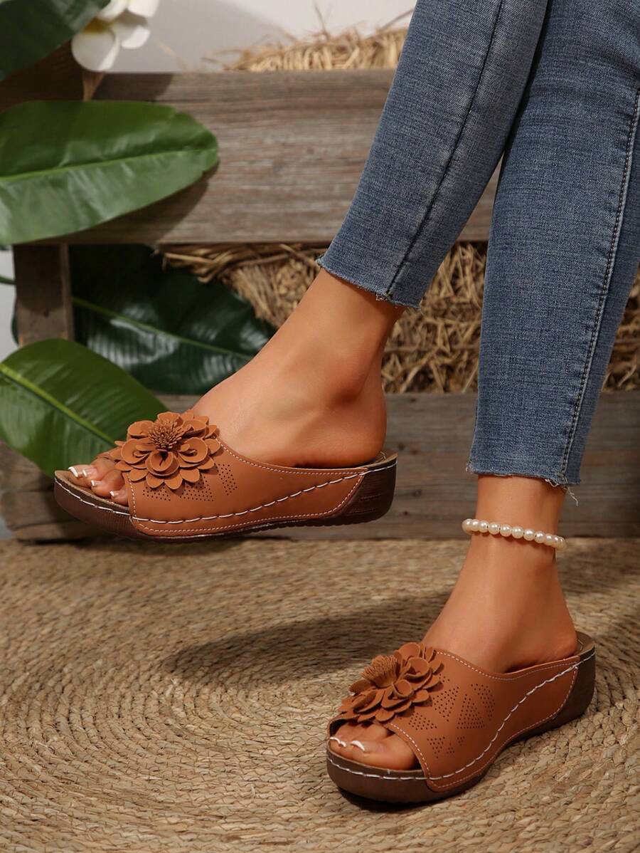 Beige wedge sandals with a delicate floral detail on the strap