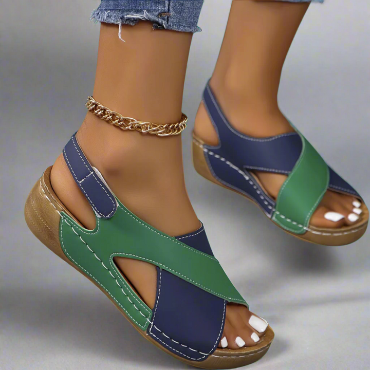A woman walking outdoors in modern colourblock orthopaedic sandals with adjustable straps.