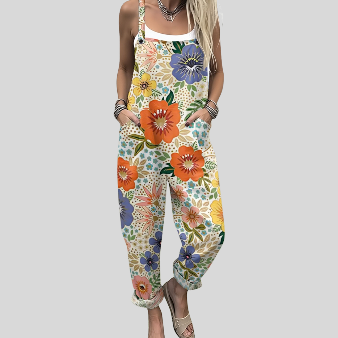 Sláine™ wide-leg dungarees with a bold, densely packed floral print in orange, blue, and green on a light background.