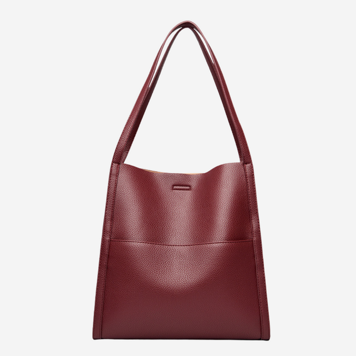A woman carrying an elegant shoulder bag with clean lines over one shoulder in town