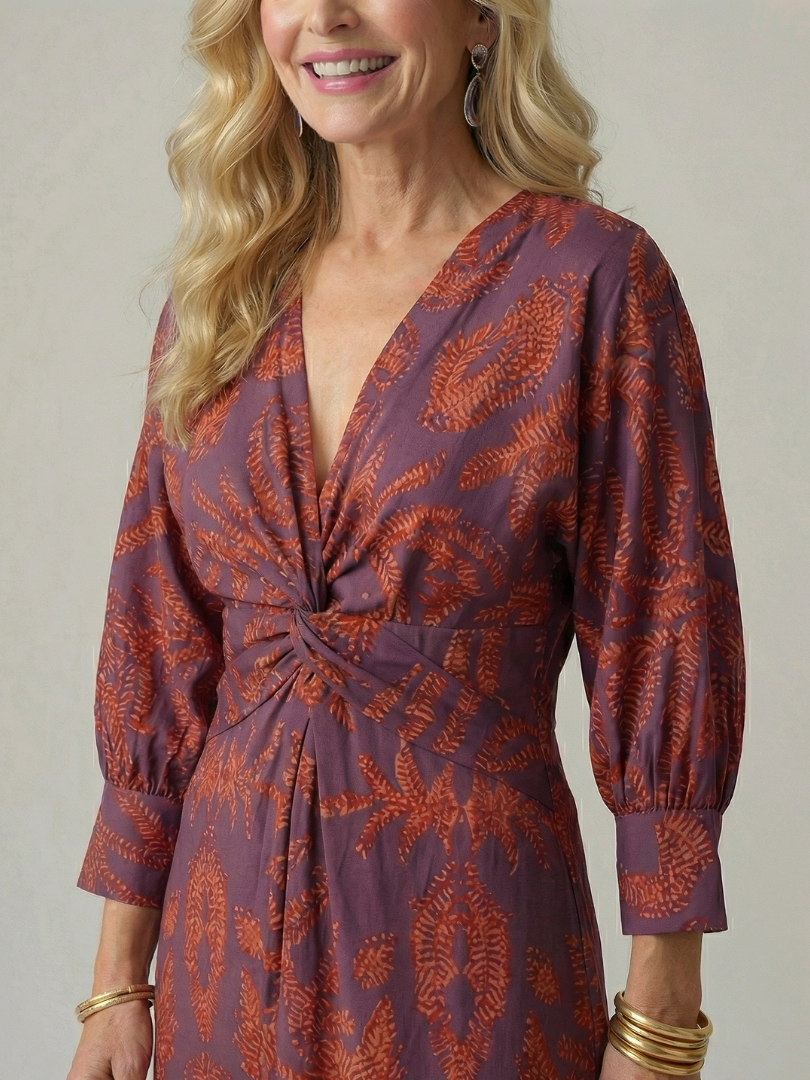 Dark green long-sleeve midi dress with diagonal wrap bodice and straight skirt in a detailed print