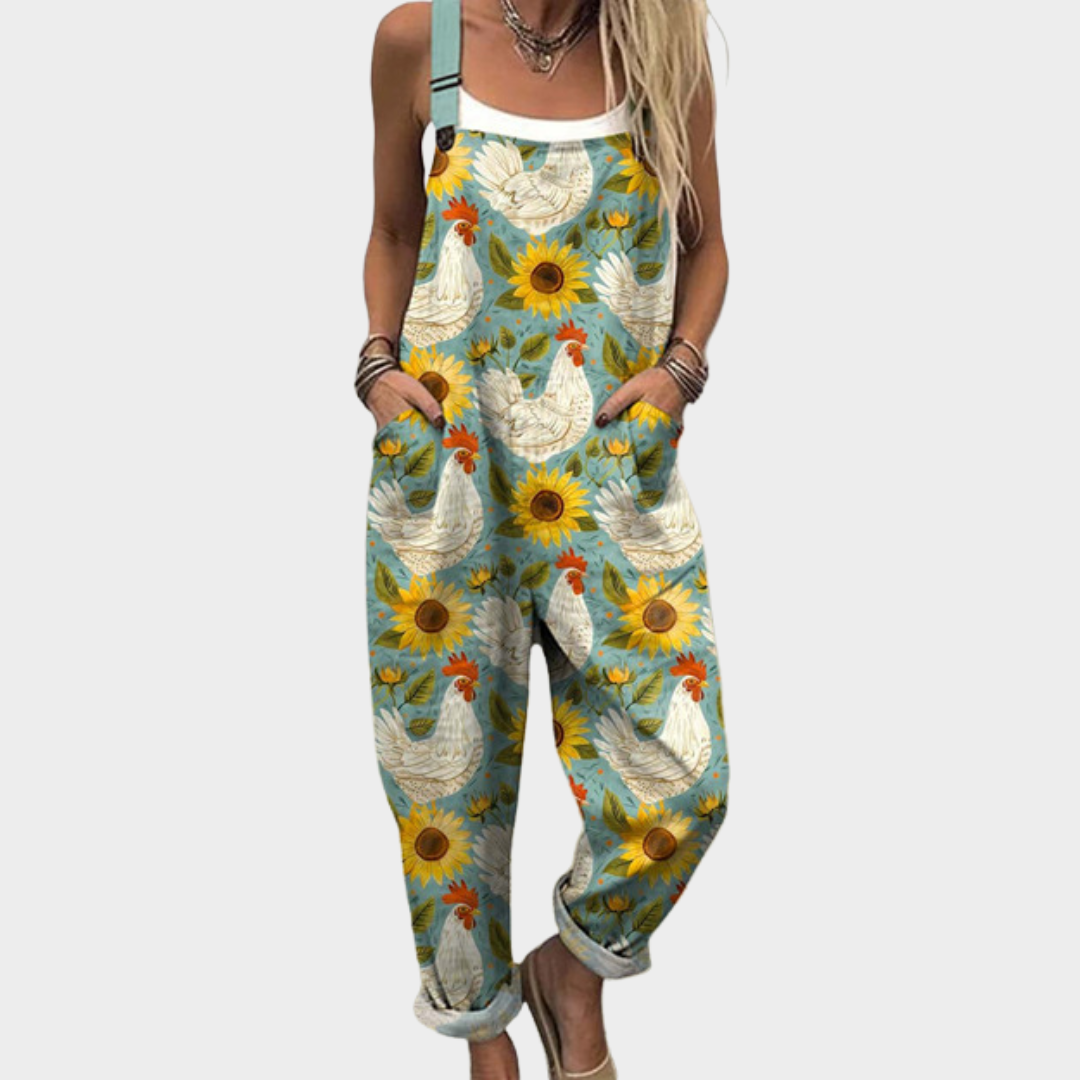 Woman wearing soft green dungarees printed with bright sunflowers and white hens