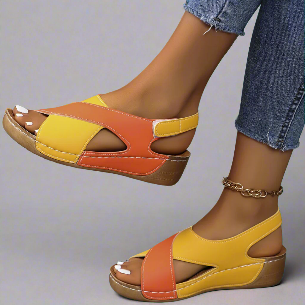 A woman walking outdoors in modern colourblock orthopaedic sandals with adjustable straps.