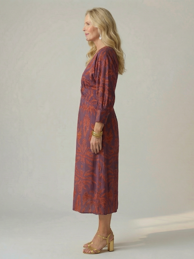 Dark green long-sleeve midi dress with diagonal wrap bodice and straight skirt in a detailed print