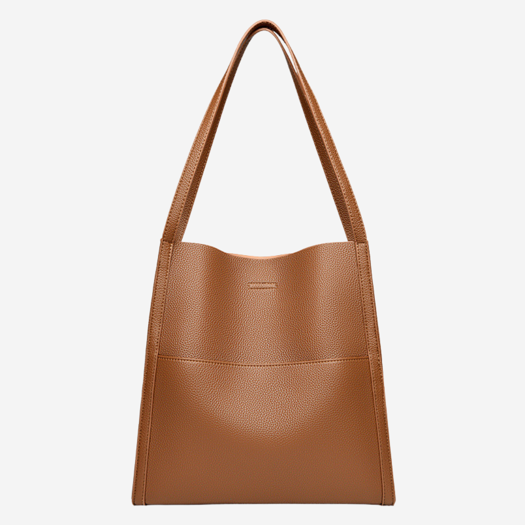 A woman carrying an elegant shoulder bag with clean lines over one shoulder in town