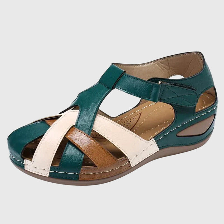 A woman in burgundy comfort sandals walking with ease on a sunny day, feet relaxed and supported.