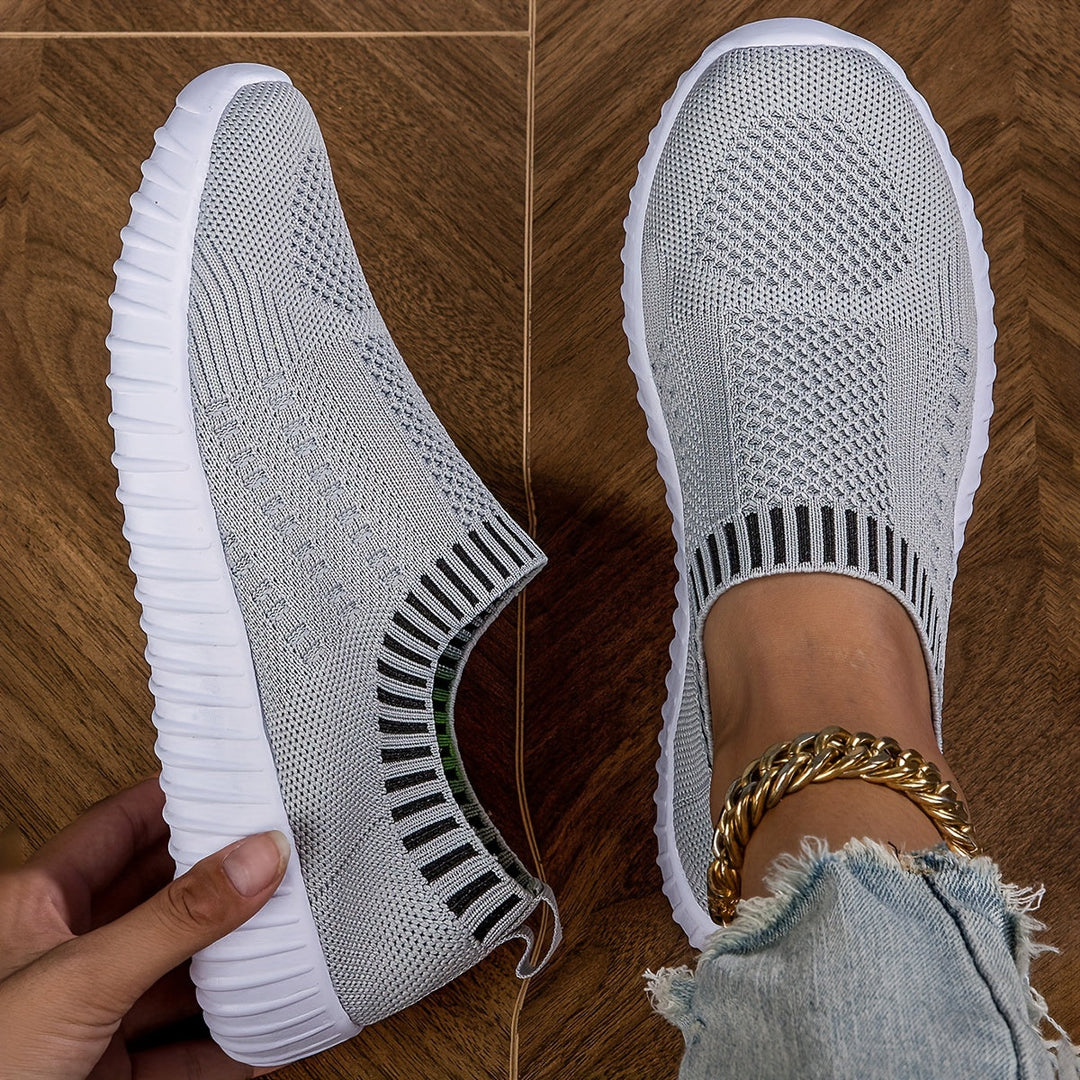 A woman slipping on ultralight sock-style trainers that hug the foot.