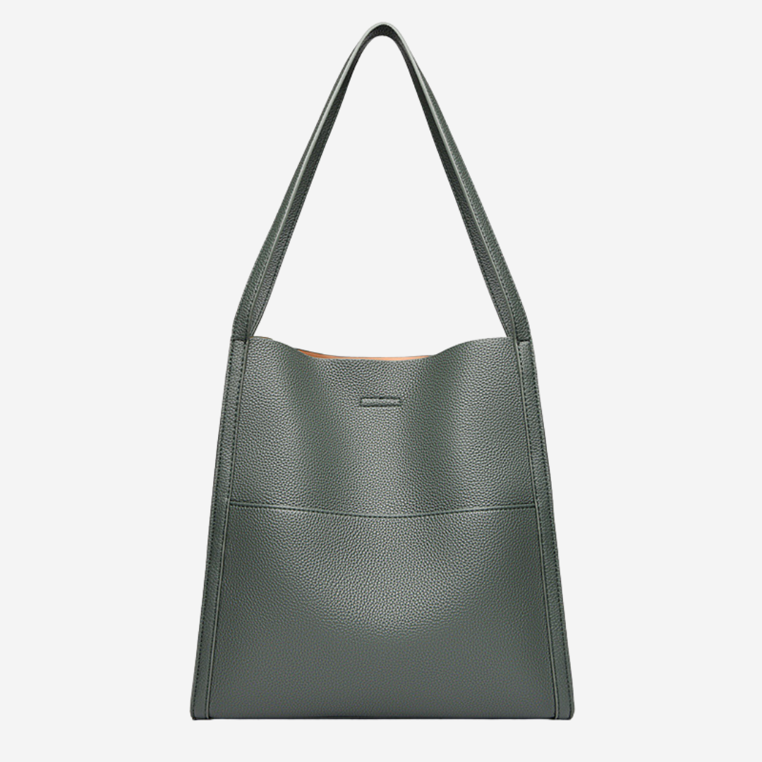 A woman carrying an elegant shoulder bag with clean lines over one shoulder in town
