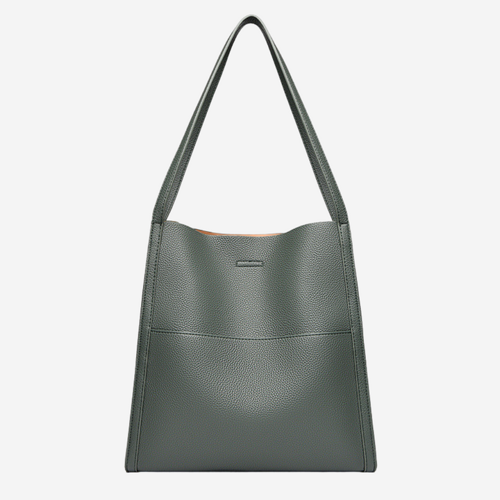 A woman carrying an elegant shoulder bag with clean lines over one shoulder in town