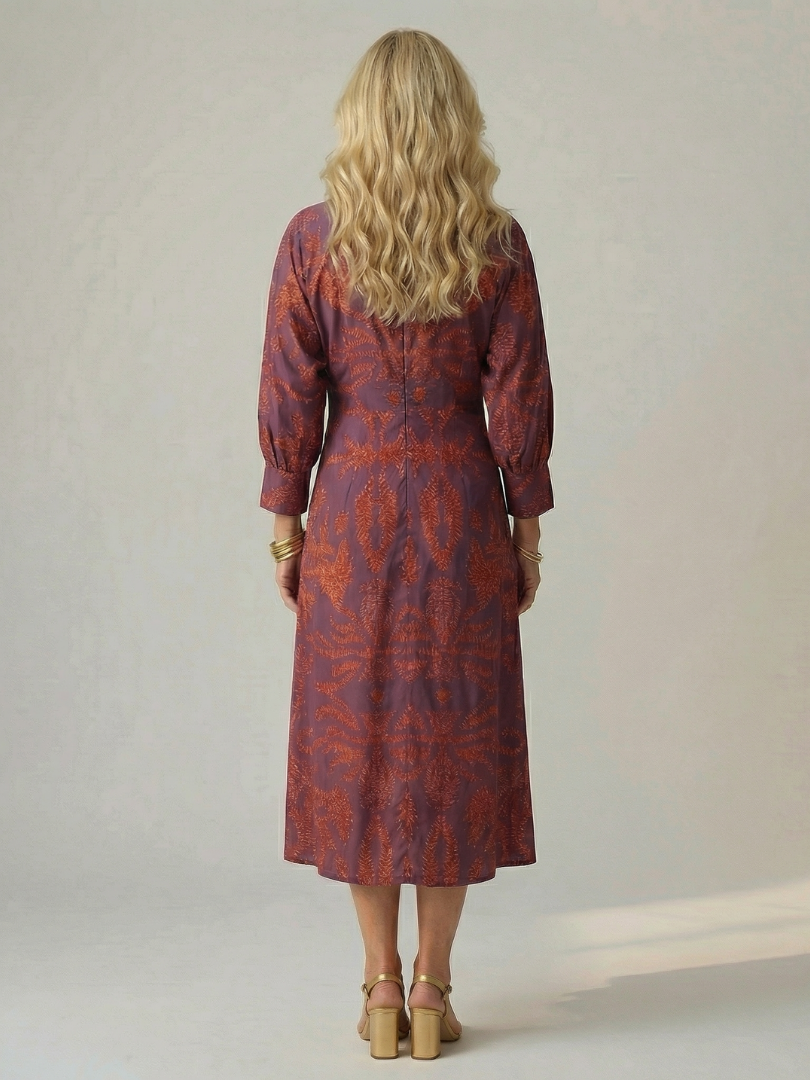Dark green long-sleeve midi dress with diagonal wrap bodice and straight skirt in a detailed print