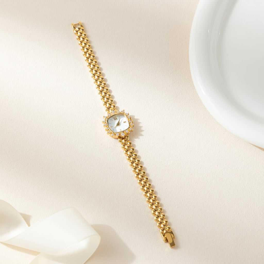 Slim women's bracelet watch with a vibrant colour detail against a simple light dial