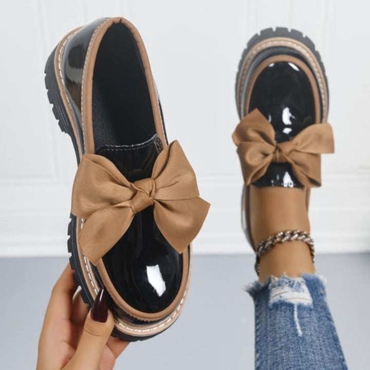 Bold loafers with a high-shine finish and statement bow detail, available in green, beige, black, brown and burgundy