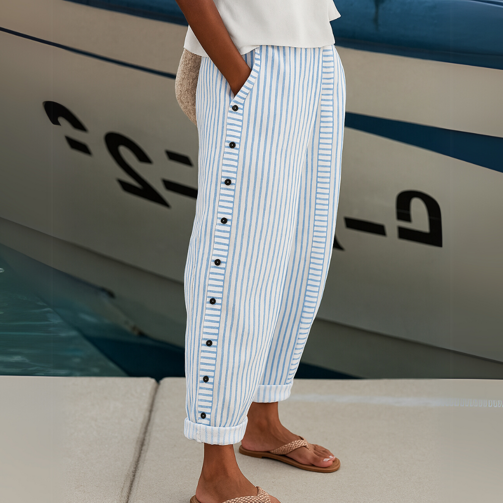 High-waisted striped trousers in black with decorative button detail along the waist