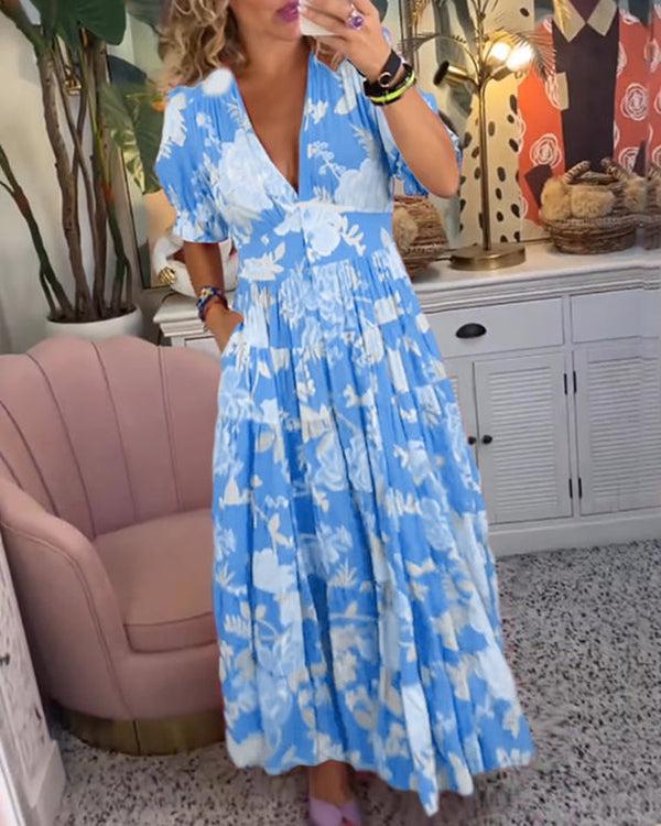 A woman wearing the Josephine bold floral maxi dress with a flowing full-length skirt at a garden gathering.
