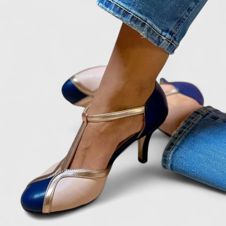 A woman wearing caramel T-strap heels, walking with grace and confidence.