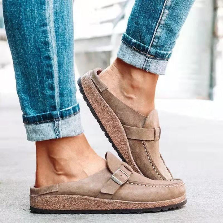 A woman wearing soft green bow loafers with cropped jeans on a city stroll.