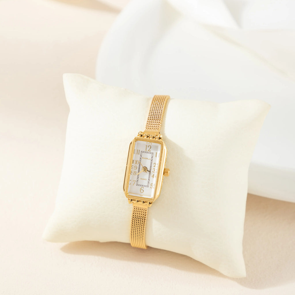 Women's classic watch with a textured strap and rounded dial in warm gold tone