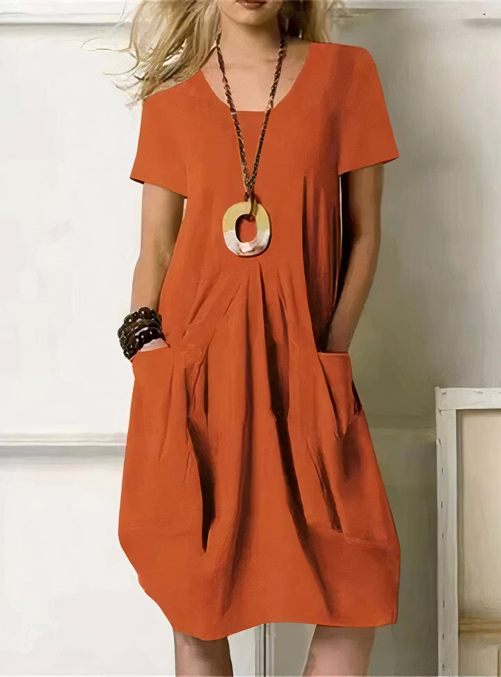Woman wearing the Pauline™ A-line midi dress with pockets and a round neckline, out on an everyday errand.