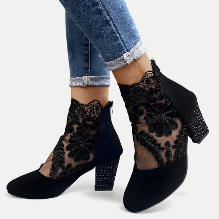 A woman wearing wide-toe orthopaedic heels, standing comfortably in an elegant everyday look.