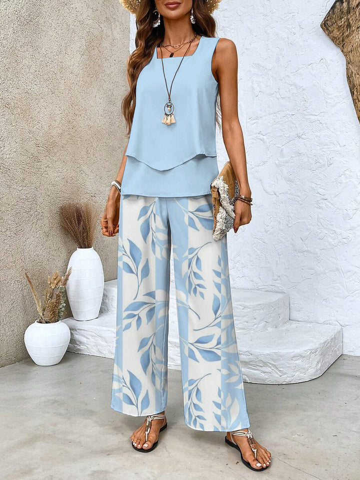 A woman wearing a layered sleeveless top with leaf-print wide-leg trousers, light and elegant.