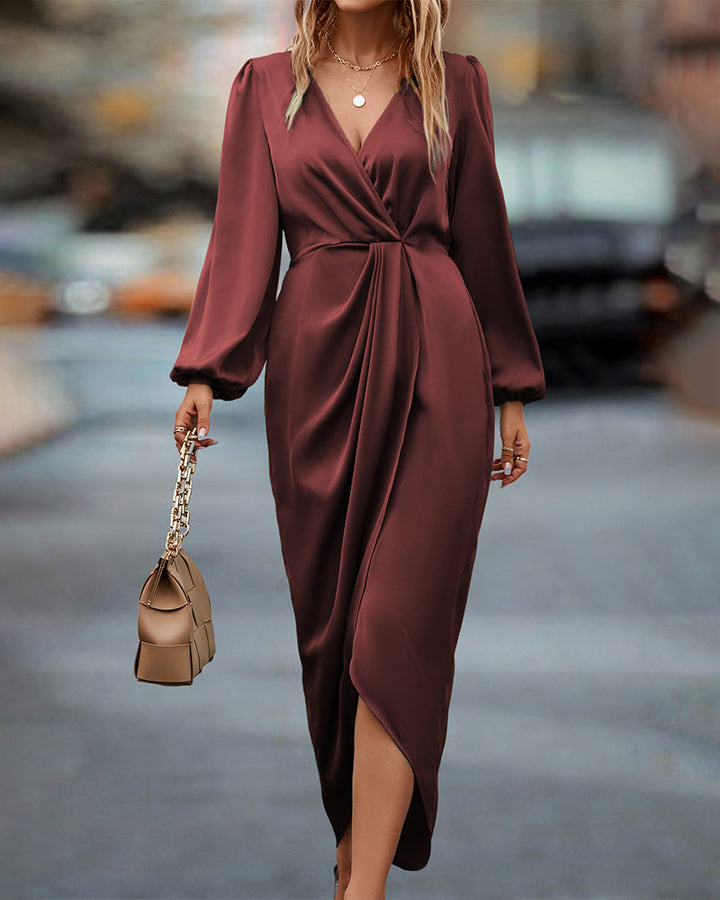 Woman in the Naomi draped evening dress with long sleeves and a softly gleaming finish, ready for an elegant night out.
