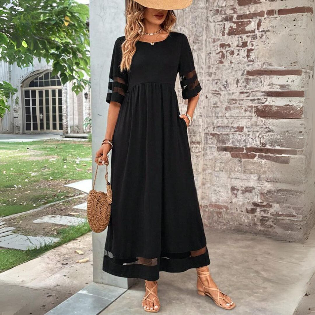 Woman wearing the Winifred™ empire waist midi dress with a flowing skirt and round neckline at a family gathering.