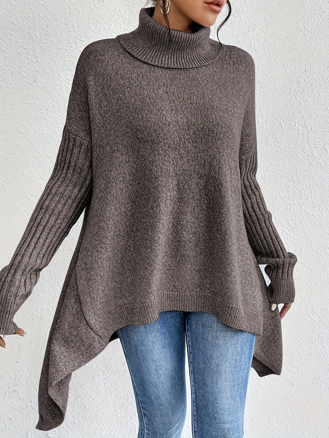 A woman wearing a stand-collar jumper with a chic asymmetric drape, warm and polished.