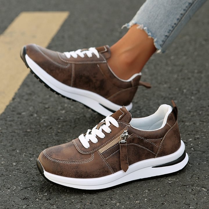A woman wearing cushioned orthopaedic trainers with a side zip