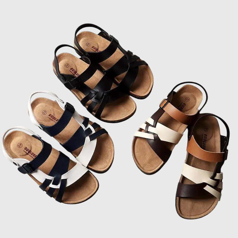 A woman in colourful cross-strap summer sandals with an adjustable ankle buckle on a warm day.