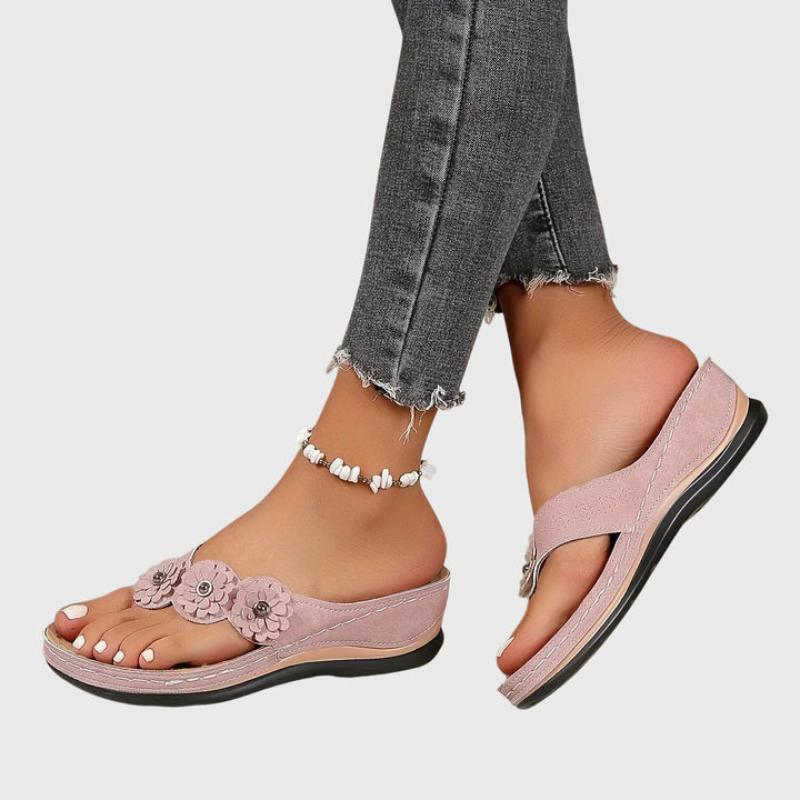 A woman wearing navy cushioned flip-flops with a supportive insole and open-front design.