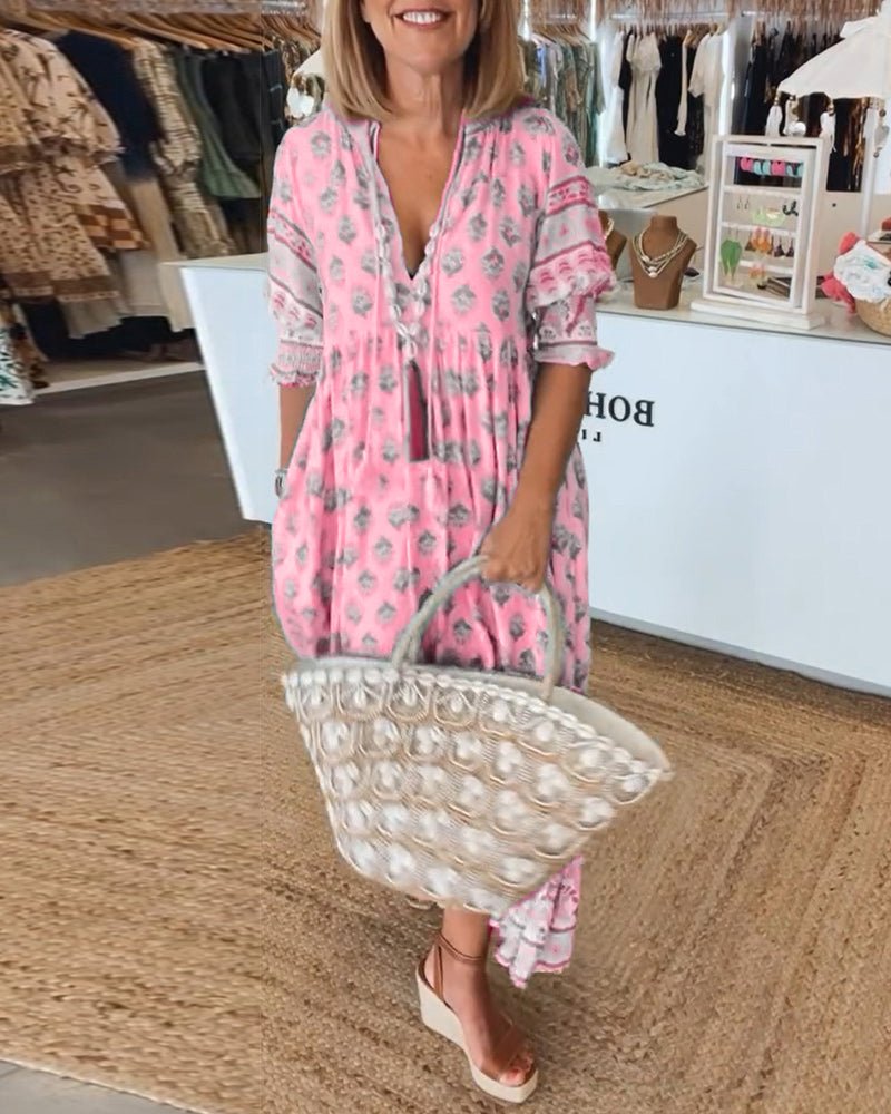 A woman wearing the Patricia boho floral midi dress with a fringed neckline and ruffled skirt.