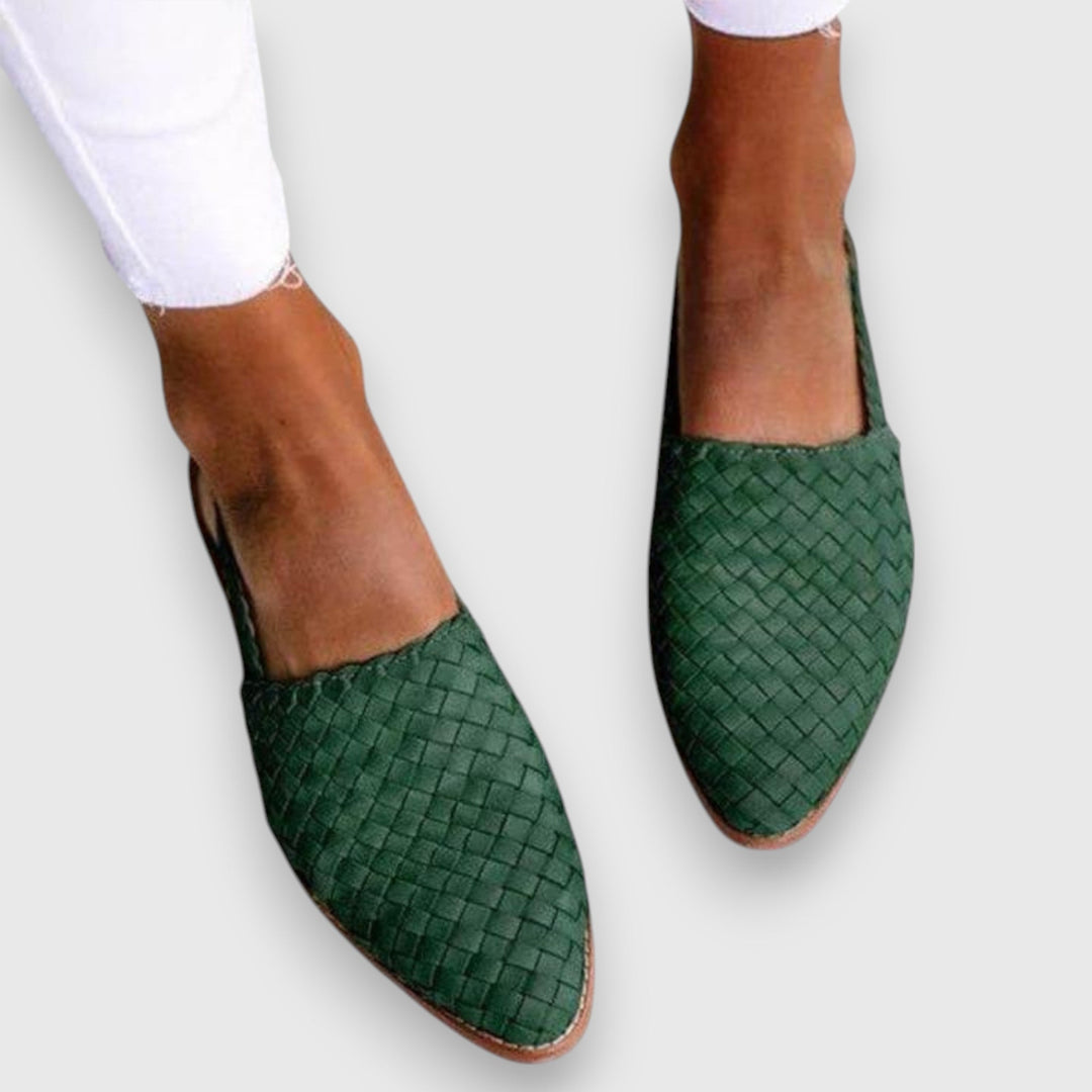 A woman wearing woven ballet flats with cropped jeans, looking relaxed and refined on a summer day.