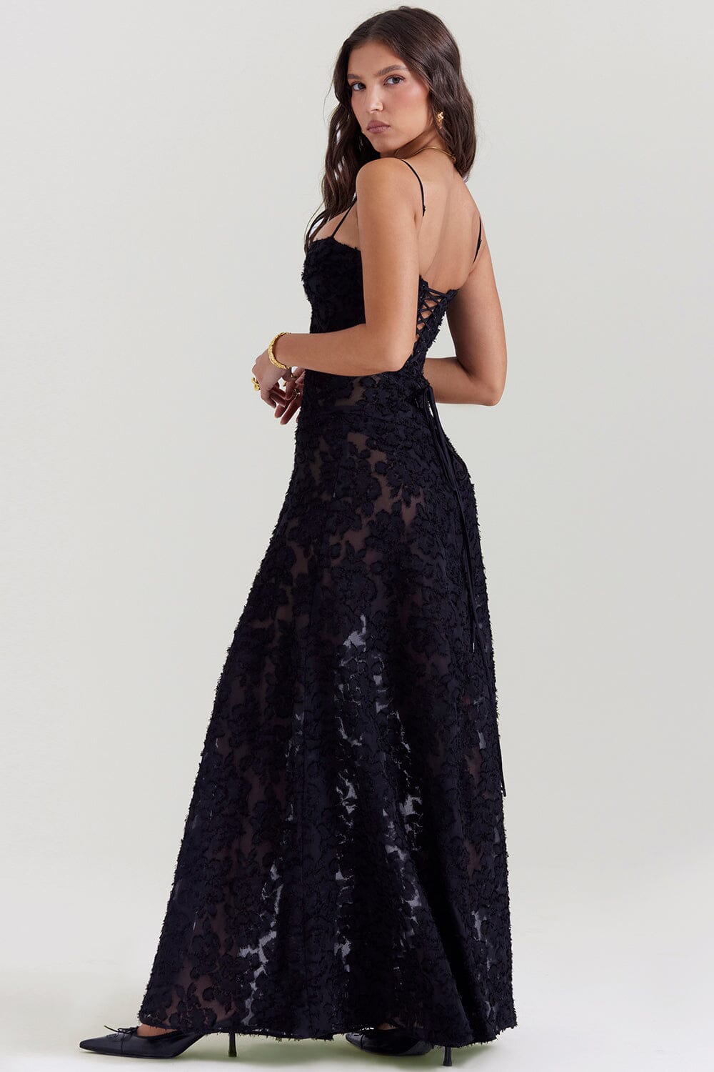An elegant floor-length occasion dress in blush pink, styled for a formal wedding or gala event