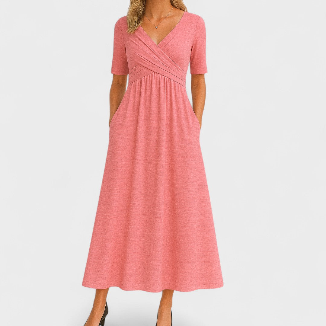 Woman wearing a mid-calf dress with a crossover V-neckline, gathered waist and gently flared skirt.