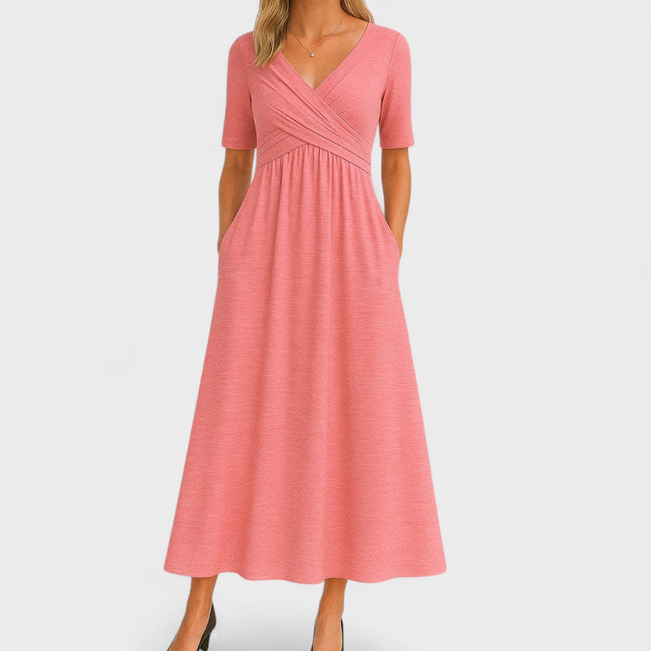 Woman wearing a mid-calf dress with a crossover V-neckline, gathered waist and gently flared skirt.
