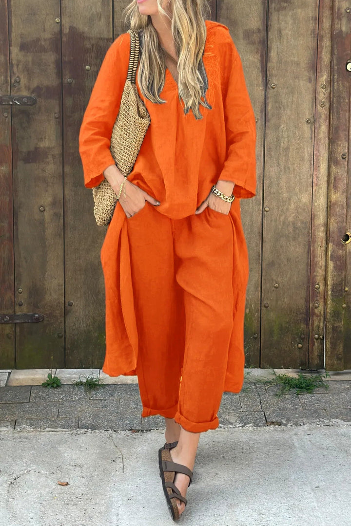 A woman wearing a blue asymmetric tunic with wide-leg trousers