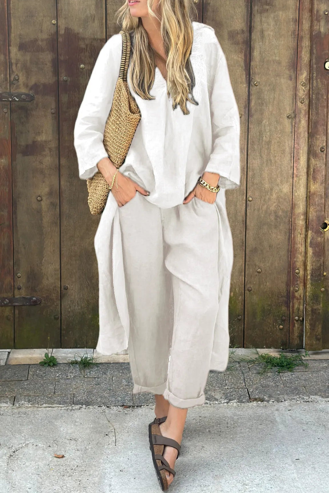 A woman wearing a blue asymmetric tunic with wide-leg trousers