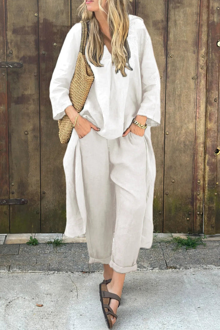 A woman wearing a blue asymmetric tunic with wide-leg trousers