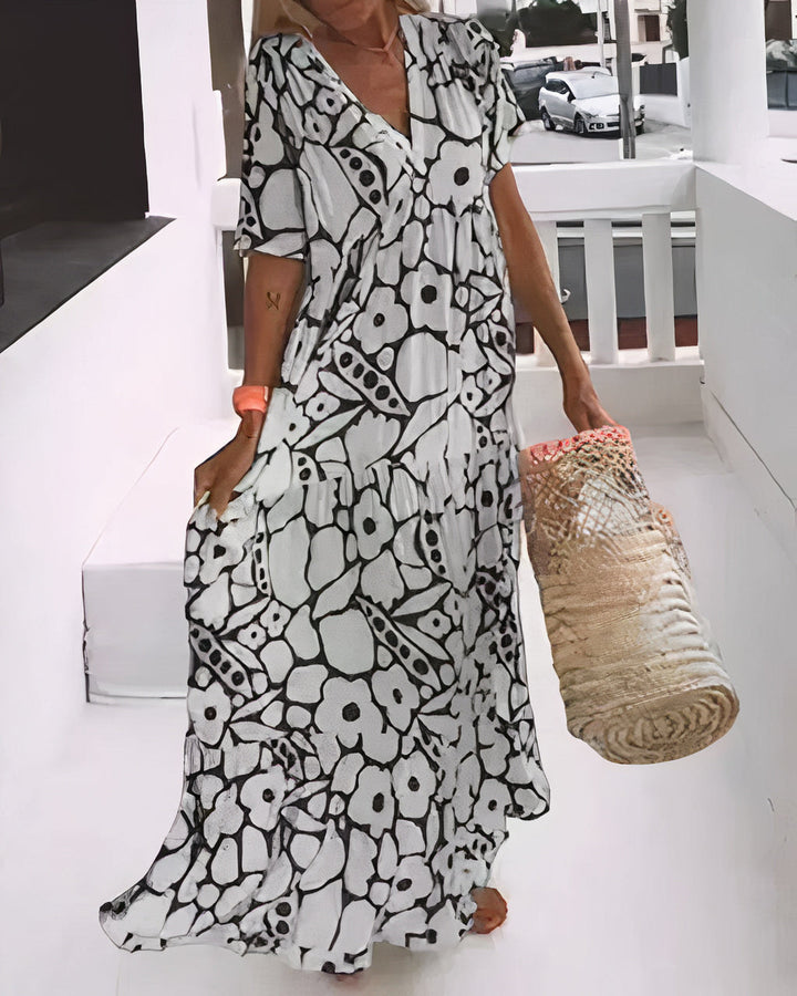 Woman wearing a flowing floral midi dress with a V-neckline while walking outdoors.